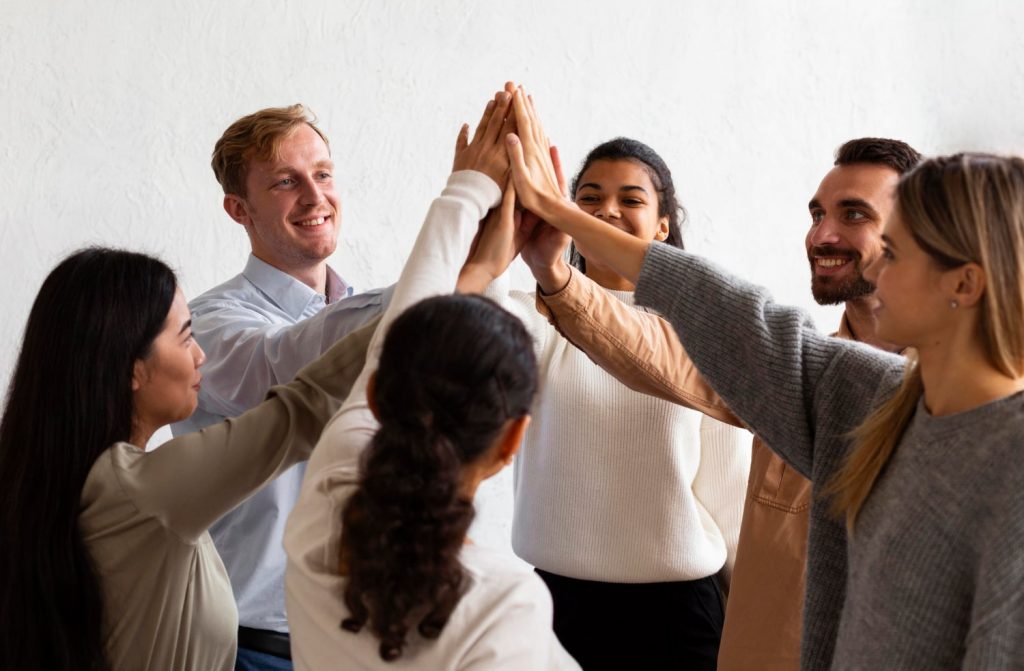 happy people high fiving each other group therapy session min